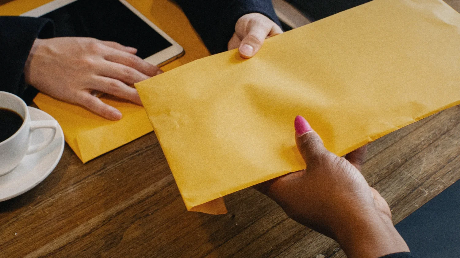 A yellow envelope of documents handed across the table